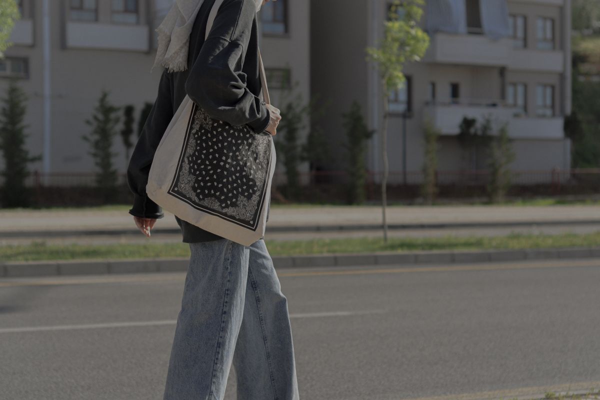 Side view of a person walking with a filled tote bag